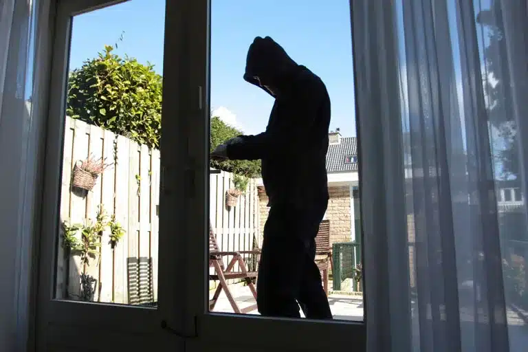 Burglar attempting to break into a home.